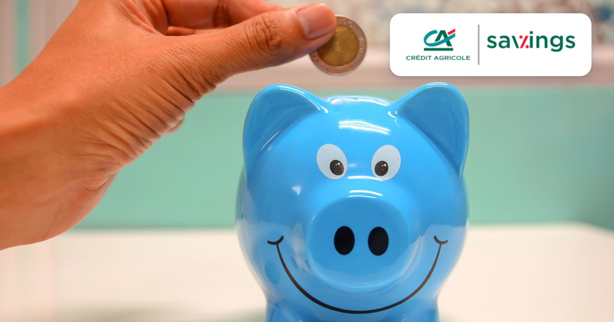 Crédit Agricole Savings Logo neben einem blauen Sparschwein, in das eine Hand eine Münze wirft