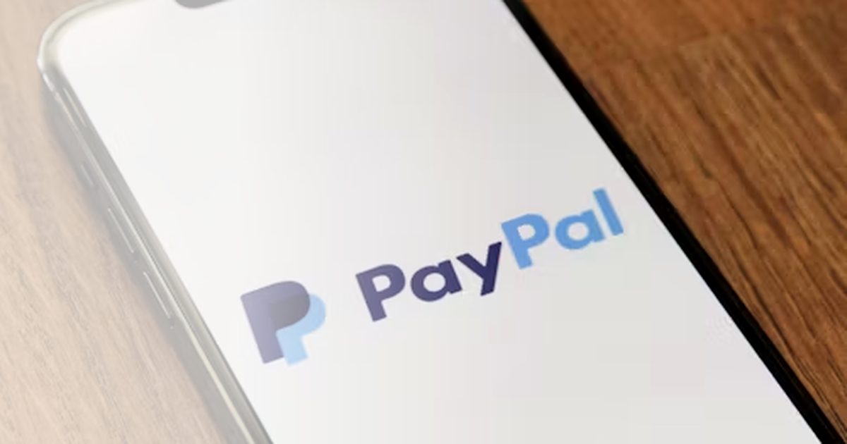 Smartphone mit PayPal-Logo auf Holztisch