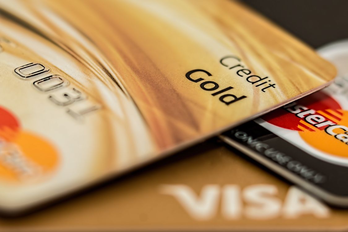 Nahaufnahme einer goldenen Kreditkarte mit Visa und Mastercard Logo
