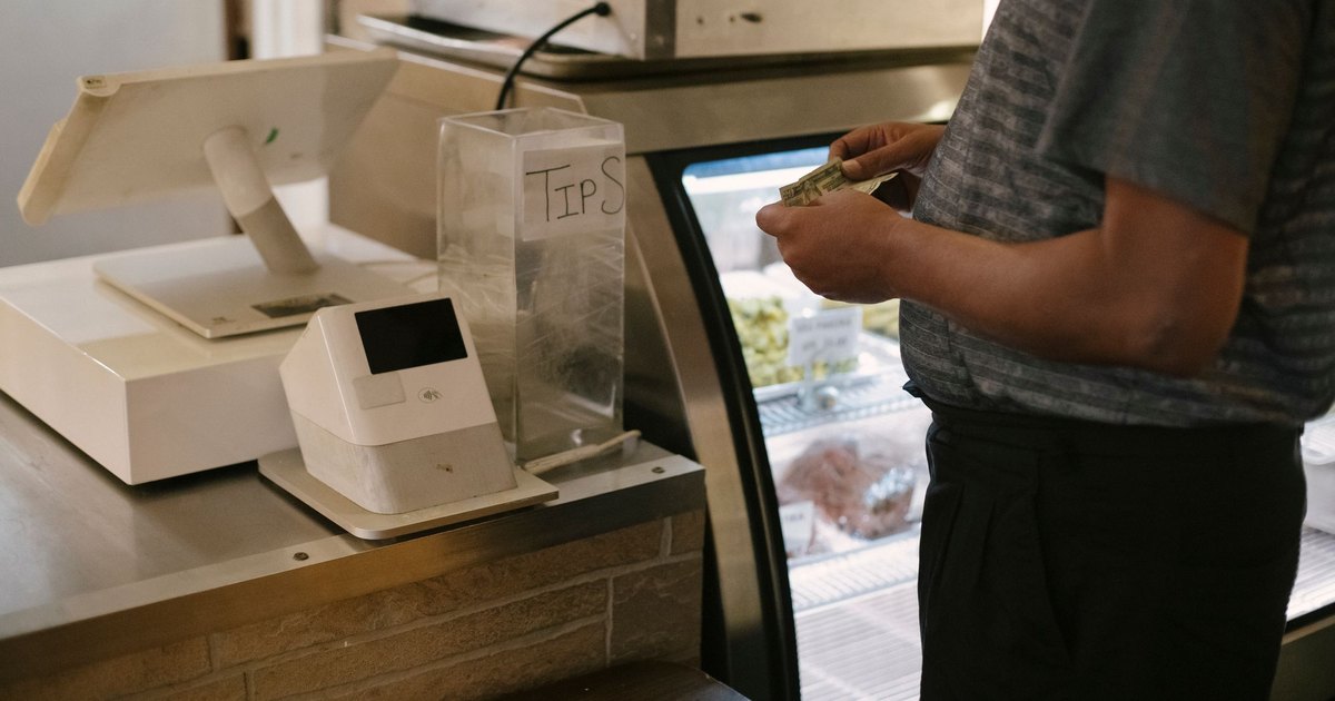 Bargeld an der Supermarktkasse: Kunde zählt Geldscheine