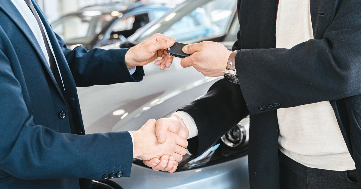 Schlüsselübergabe und Handschlag bei der Autovermietung