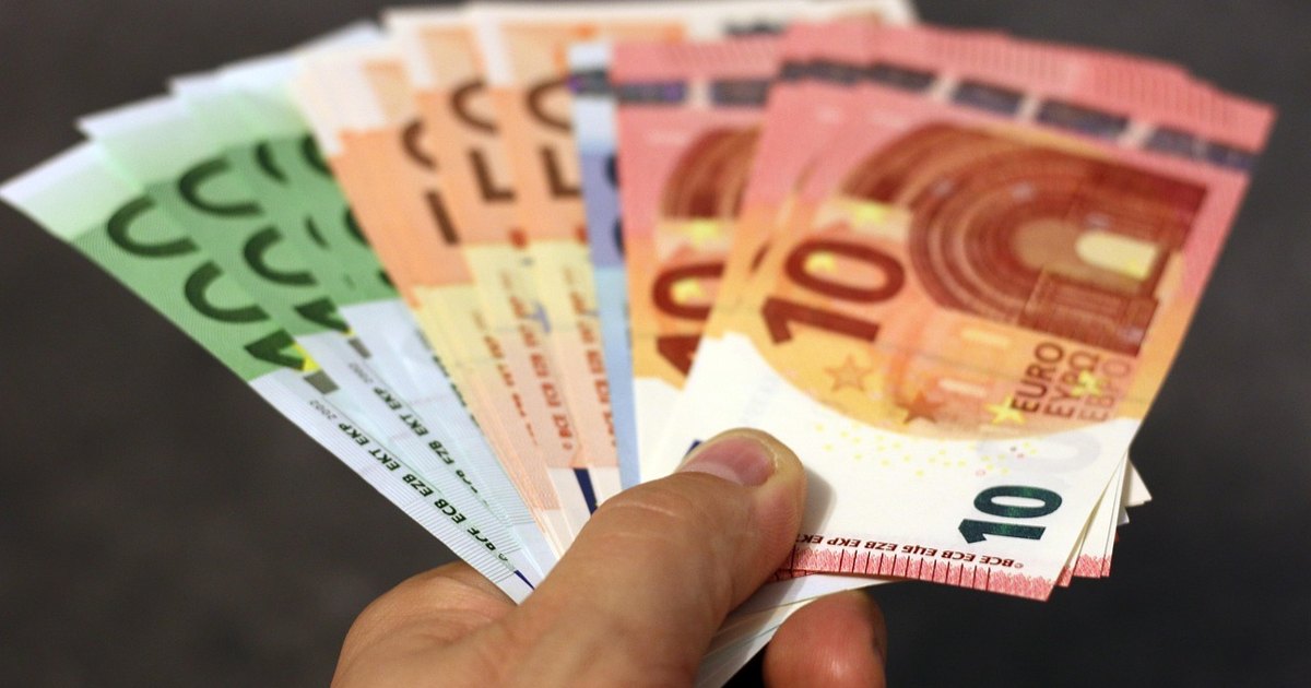 Hand mit Euro-Scheinen: Bargeld abheben und einzahlen mit Cash26