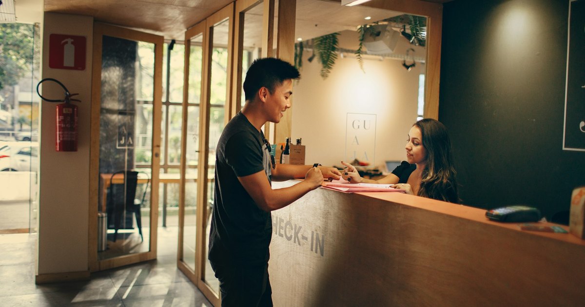 Gast checkt an der Hotelrezeption ein und bezahlt