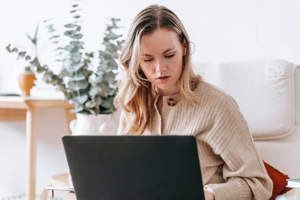 Selbstständige arbeitet am Laptop und vergleicht Geschäftskonto-Kosten